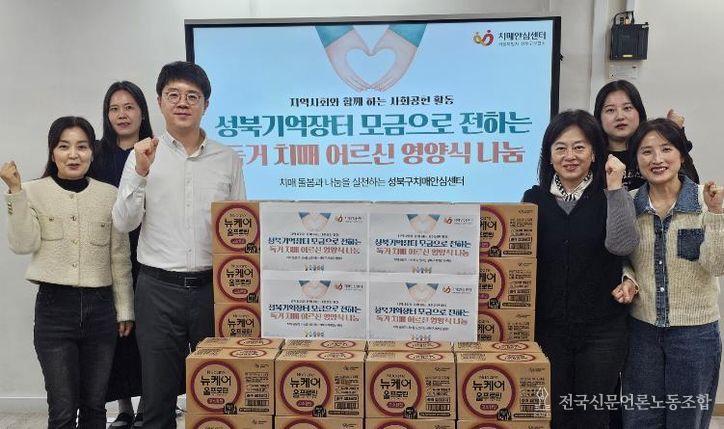 성북구치매안심센터 관계자들이 취약계층 치매 독거 어르신 지원 물품 전달식 후 기념촬영을 하고 있다