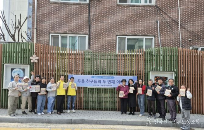 아산시 온양3동 주민자치회 위원 및 전시 참여 학부모들이 담장 갤러리에서 작품 교체 작업을 진행하고 있다.