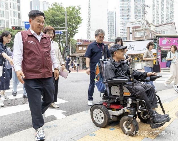 박강수 마포구청장이 휠체어를 탄 주민과 함께 새로 조성된 무장애길을 걷고 있다.